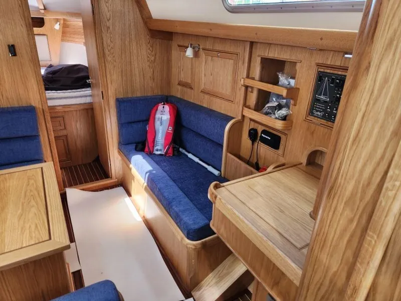 Slide: The Image of Interior of 2025 Rustler 37 sailboat with wooden finish and blue seating. - 25