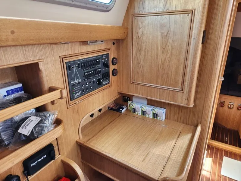 Slide: The Image of 2025 Rustler 37 yacht interior with wooden cabinetry and control panel. - 26
