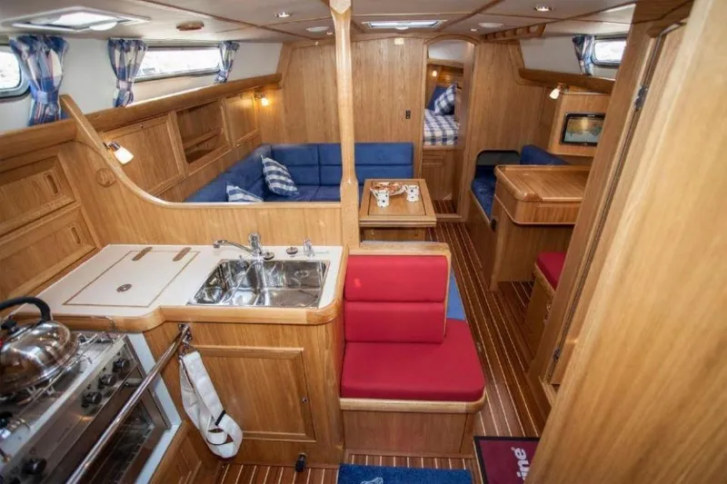 Slide: The Image of Interior of 2025 Rustler 37 yacht with wooden finish, kitchen, and seating area. - 30