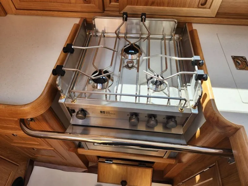 Slide: The Image of Rustler 37 yacht kitchen with a modern stainless steel stove, 2025 model. - 36