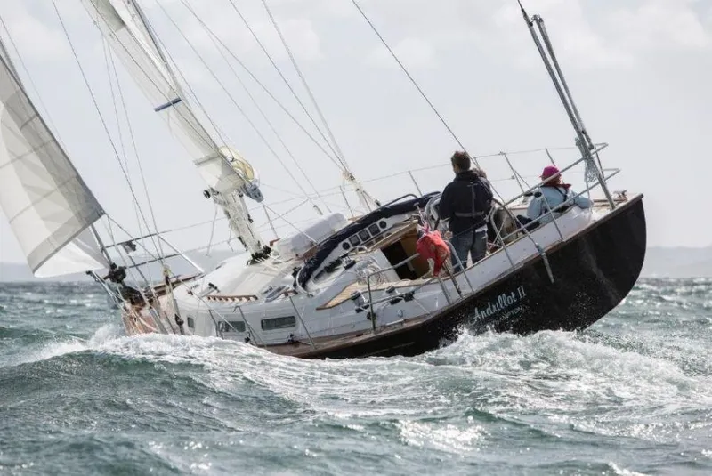 Slide: The Image of Sailing on a 2025 Rustler 37 yacht in choppy waters, crew navigating skillfully. - 4