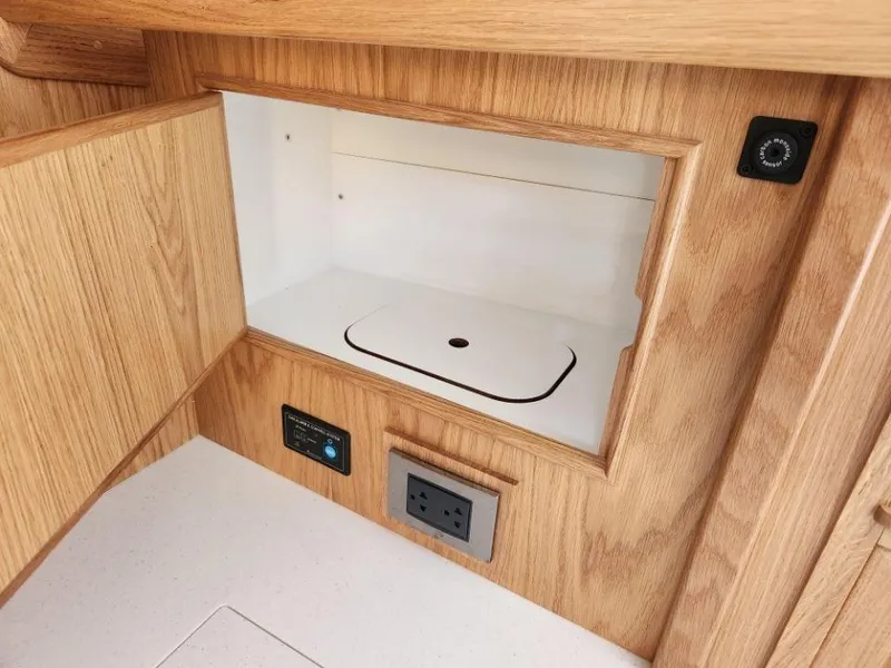 Slide: The Image of 2025 Rustler 37 interior cabinet with electrical outlet and control panel. - 40