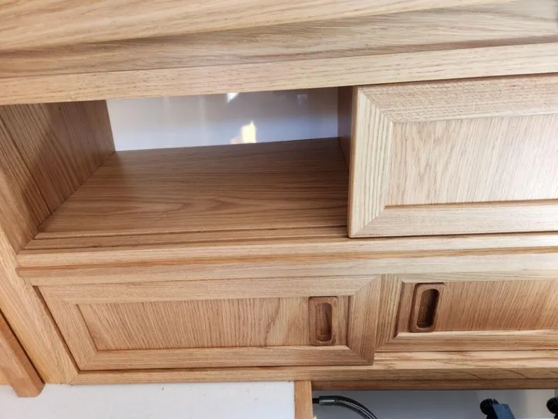 Slide: The Image of Wooden cabinetry detail inside a 2025 Rustler 37, showcasing open and closed compartments. - 42