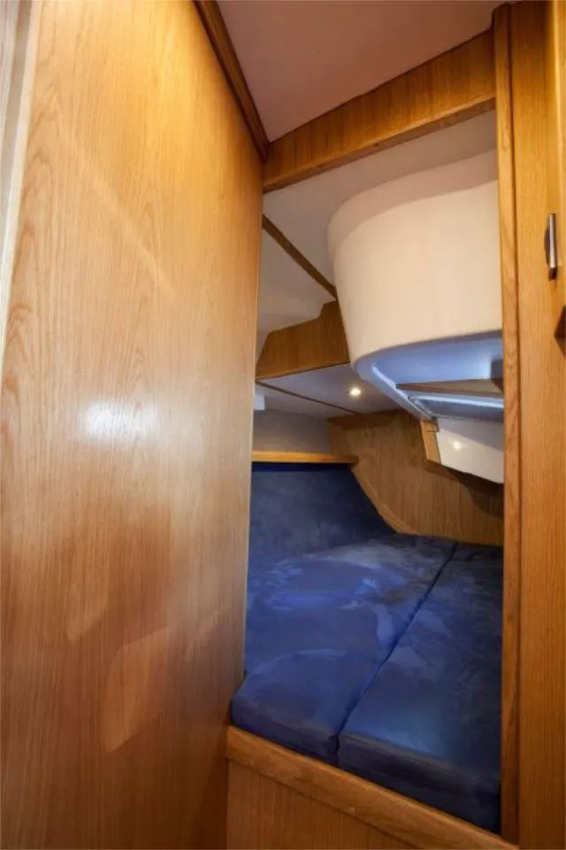Slide: The Image of 2025 Rustler 37 yacht interior with cozy wooden cabin and blue bedding. - 46