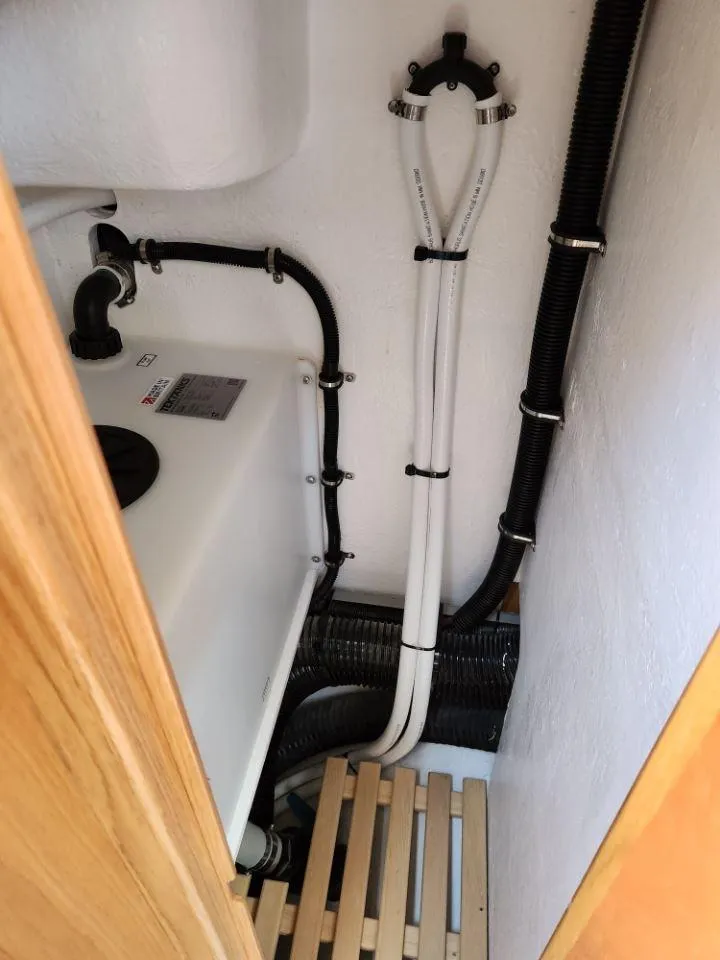 Slide: The Image of Rustler 37 yacht plumbing system, 2025 model, featuring pipes and wooden flooring. - 48