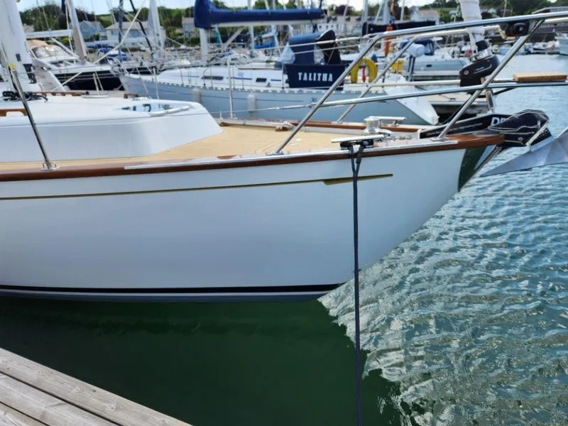 Slide: The Image of 2025 Rustler 37 yacht docked in a marina, featuring sleek design and wooden accents. - 7