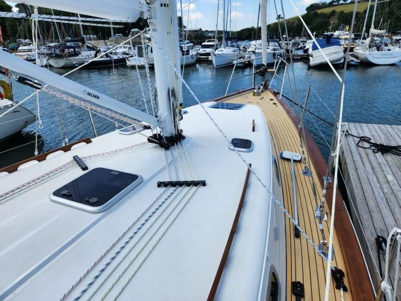 Slide: The Image of 2025 Rustler 37 sailboat docked in a marina, showcasing its sleek deck design. - 9