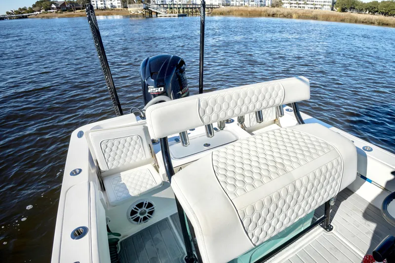 Slide: The Image of 2021 Contender 25 Bay boat with cushioned seating and Yamaha 250 engine on a calm lake. - 10