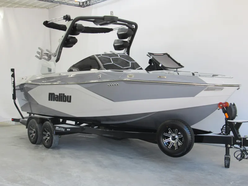 Slide: The Image of 2025 Malibu 23 LSV boat on trailer, sleek design, gray and white color scheme. - 1
