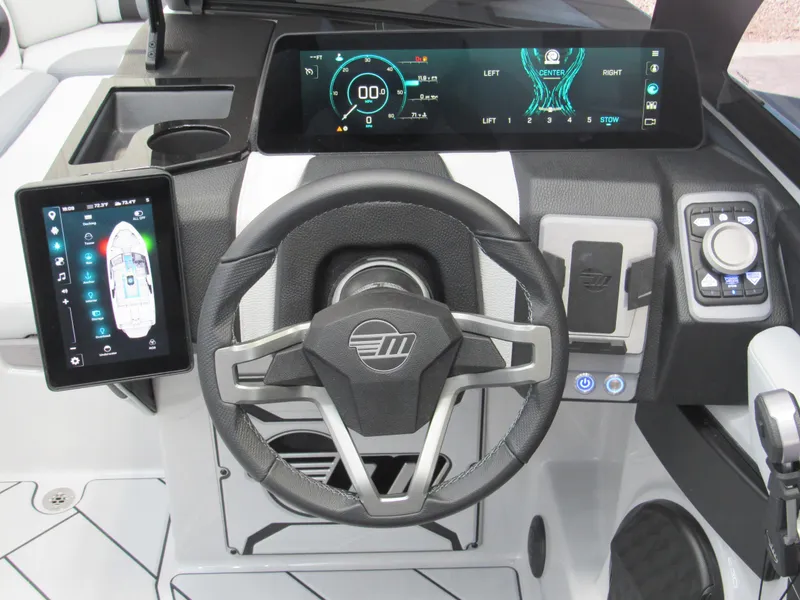 Slide: The Image of 2025 Malibu 23 LSV boat dashboard with advanced digital displays and steering wheel. - 11
