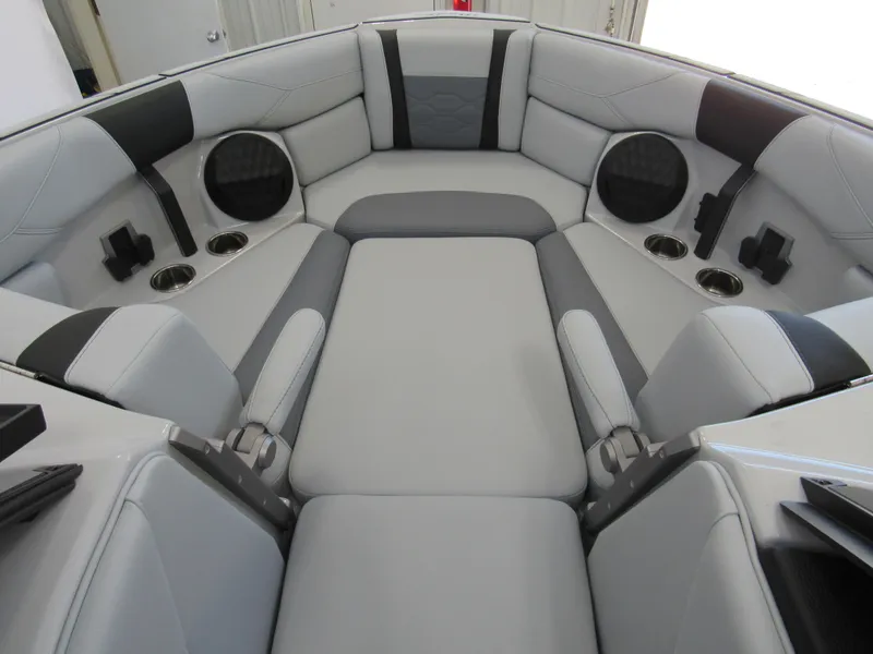 Slide: The Image of 2025 Malibu 23 LSV boat interior with gray seating and cup holders. - 12