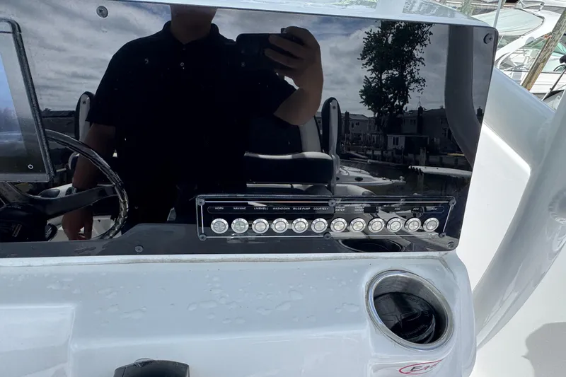 Slide: The Image of 2025 Tidewater 210 LXF boat dashboard with control panel and cup holder. - 12