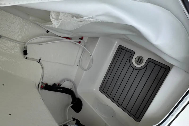 Slide: The Image of Interior view of 2025 Tidewater 210 LXF boat, featuring drainage and plumbing components. - 14