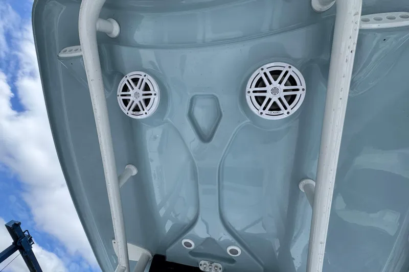 Slide: The Image of 2025 Tidewater 210 LXF boat underside with speakers, white rails, and blue sky background. - 21