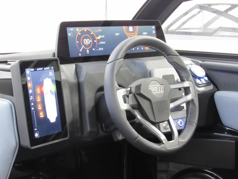 Slide: The Image of 2025 Malibu Wakesetter 22 MXZ dashboard with modern digital displays and steering wheel. - 13