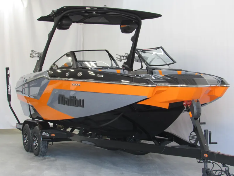 Slide: The Image of 2025 Malibu Wakesetter 22 MXZ boat in orange and gray on a trailer. - 3