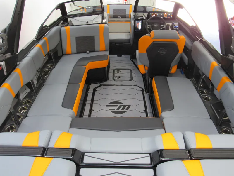 Slide: The Image of 2025 Malibu Wakesetter 22 MXZ interior with gray and orange seating, modern dashboard. - 7