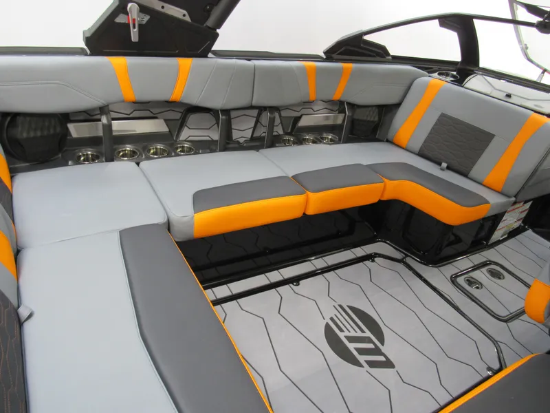 Slide: The Image of 2025 Malibu Wakesetter 22 MXZ interior with gray and orange seating, stylish design. - 8