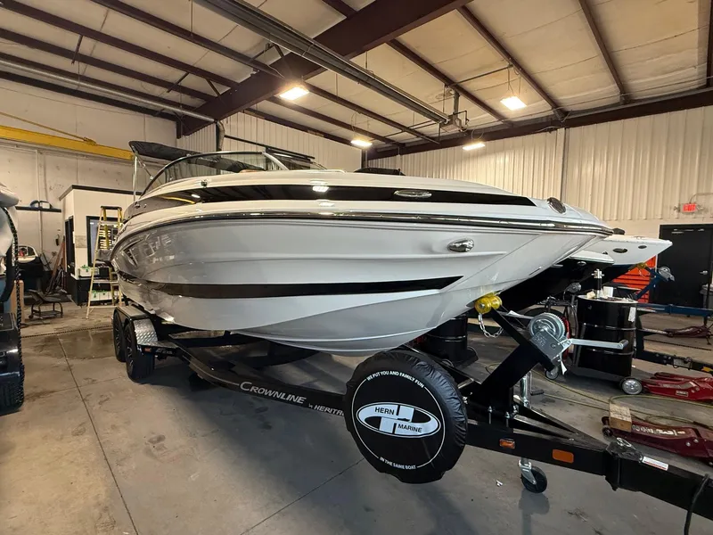 Slide: The Image of 2024 Crownline Eclipse E235 boat on trailer in indoor storage facility. - 12