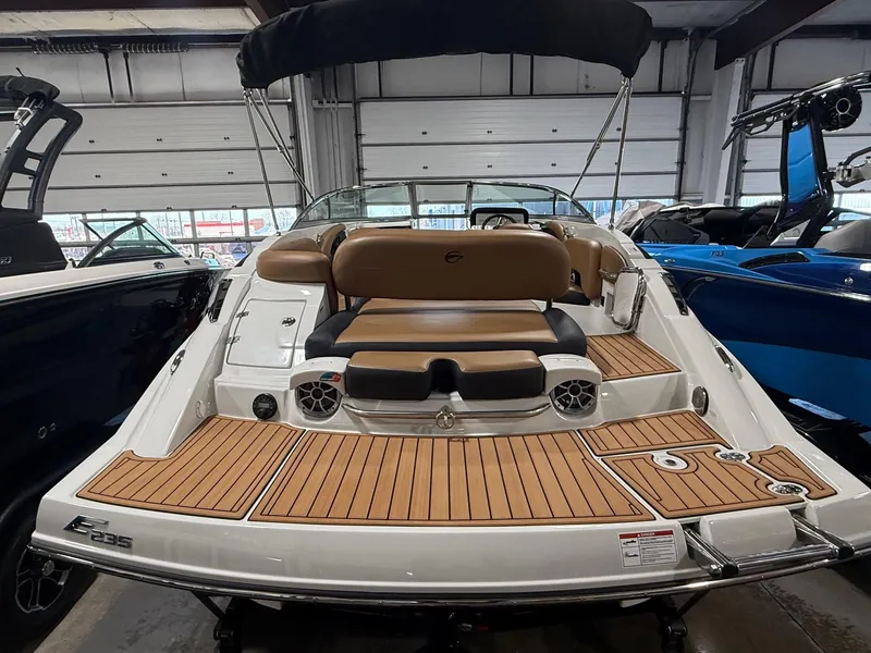Slide: The Image of 2024 Crownline Eclipse E235 boat with teak deck and seating in showroom. - 5