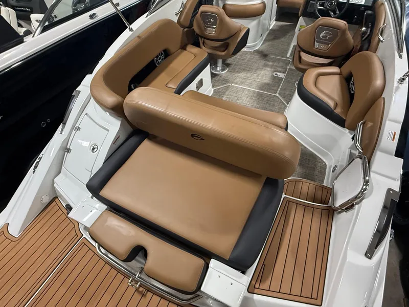 Slide: The Image of 2024 Crownline Eclipse E235 boat interior with tan leather seating and wood accents. - 6