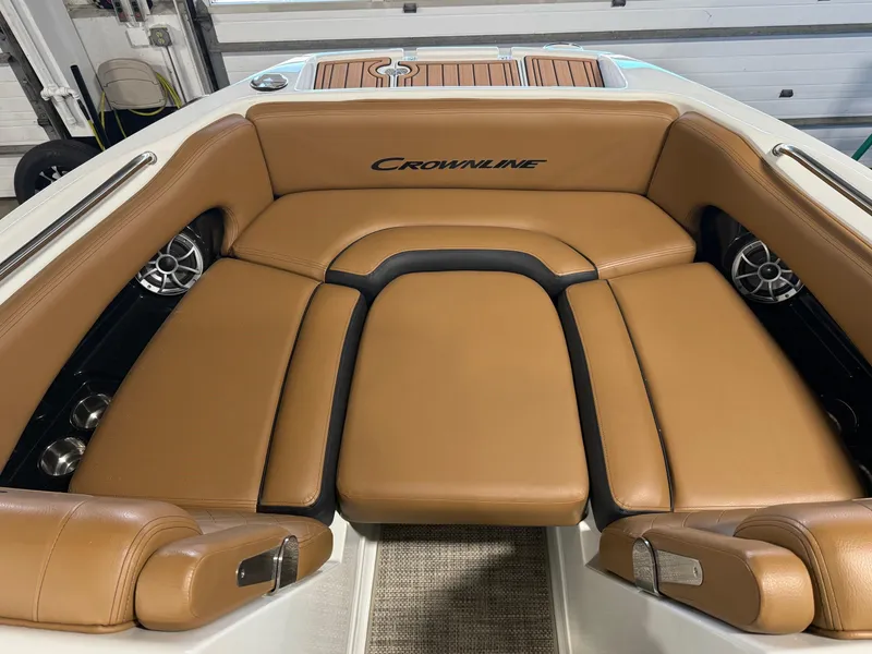 Slide: The Image of 2024 Crownline Eclipse E235 boat interior with tan leather seating and built-in speakers. - 7