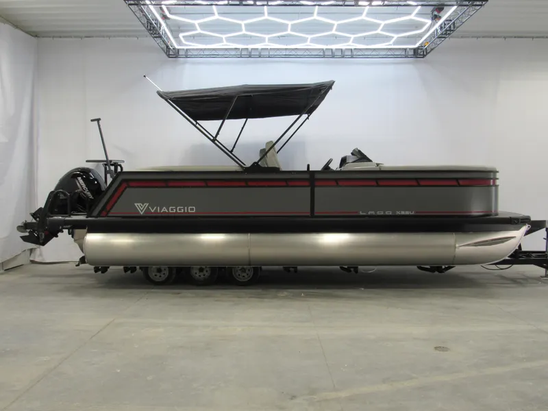 Slide: The Image of 2025 Viaggio Lago X22U pontoon boat in showroom with canopy and trailer. - 0