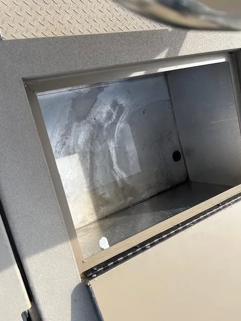 Slide: The Image of 2023 SeaArk Bayrunner 210 storage compartment with metal interior and textured exterior. - 10