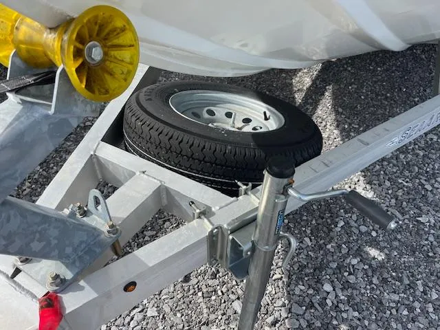 Slide: The Image of 2023 SeaArk Bayrunner 210 trailer with spare tire on gravel surface. - 13