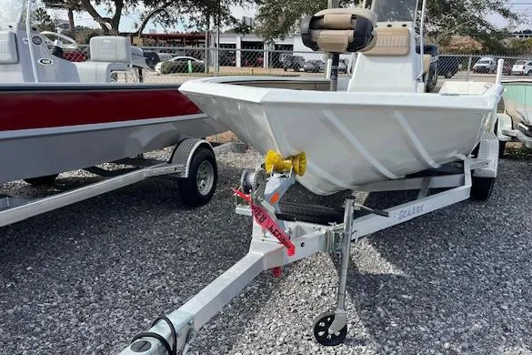 Slide: The Image of 2023 SeaArk Bayrunner 210 boat on trailer, parked on gravel lot. - 3