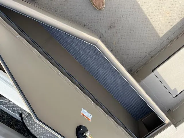 Slide: The Image of 2023 SeaArk Bayrunner 210 storage compartment with textured flooring and secure latch. - 9