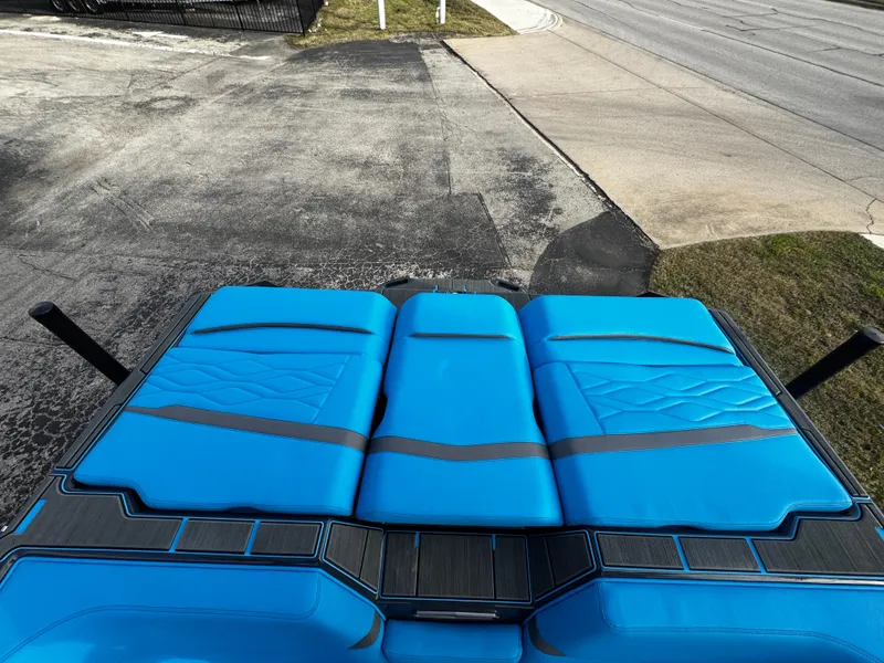 Slide: The Image of 2025 Supra SE 550 boat with vibrant blue seating, parked on a concrete surface. - 15