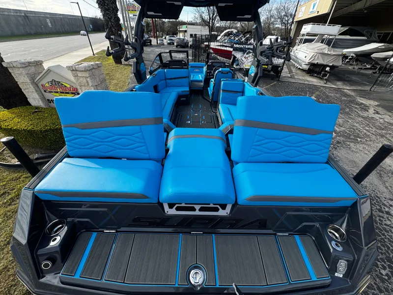 Slide: The Image of 2025 Supra SE 550 boat with vibrant blue seating and spacious interior design. - 16