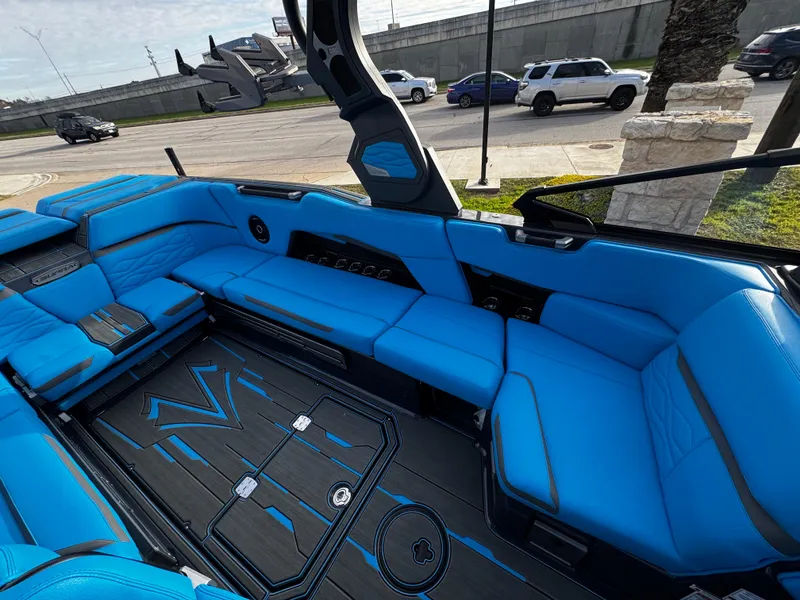 Slide: The Image of 2025 Supra SE 550 boat interior with vibrant blue seating and sleek design. - 24