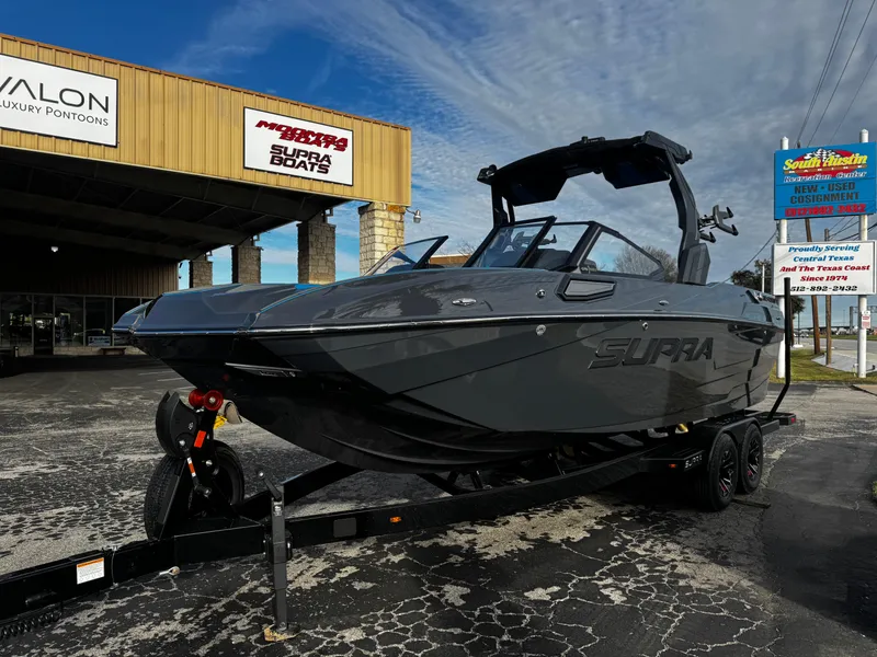 Slide: The Image of 2025 Supra SE 550 boat on trailer outside dealership. - 3