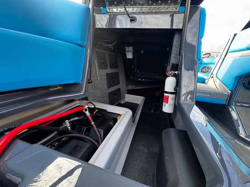 Slide: The Image of 2025 Supra SE 550 interior storage compartment with fire extinguisher and blue seating. - 33