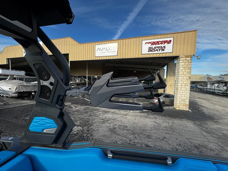 Slide: The Image of 2025 Supra SE 550 boat at dealership with blue interior and modern design. - 36