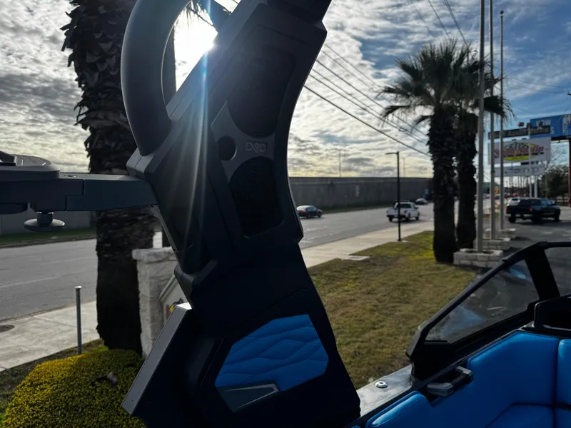 Slide: The Image of 2025 Supra SE 550 boat interior with blue accents, palm trees, and road in background. - 39