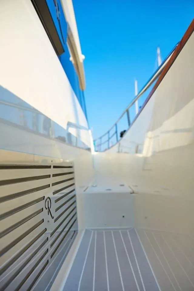 Slide: The Image of Rustler 41 yacht deck, 2025 model, featuring sleek design and modern finishes under clear blue sky. - 12