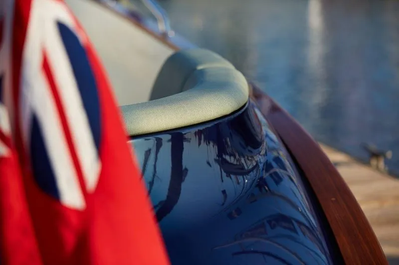 Slide: The Image of Close-up of a 2025 Rustler 41 yacht with a red flag and glossy blue hull. - 17