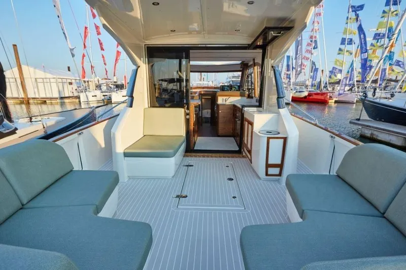 Slide: The Image of Luxurious 2025 Rustler 41 yacht interior with seating, docked at marina with colorful flags. - 20