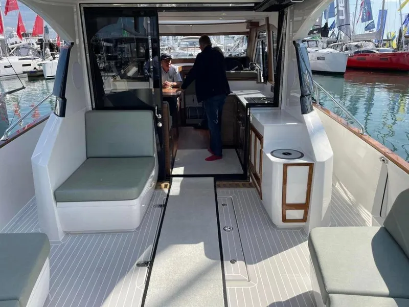 Slide: The Image of 2025 Rustler 41 yacht interior with seating and kitchenette, docked at marina. - 23