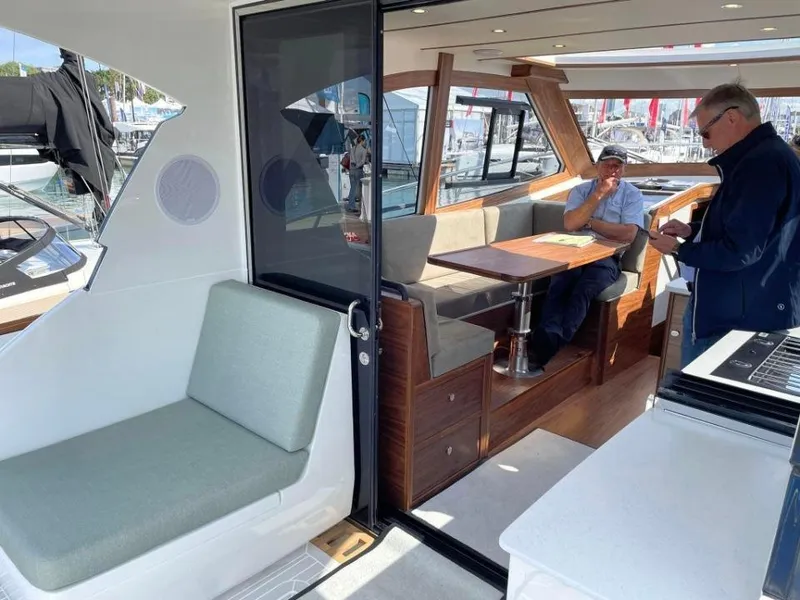 Slide: The Image of Interior of 2025 Rustler 41 yacht with seating area and two people conversing. - 24