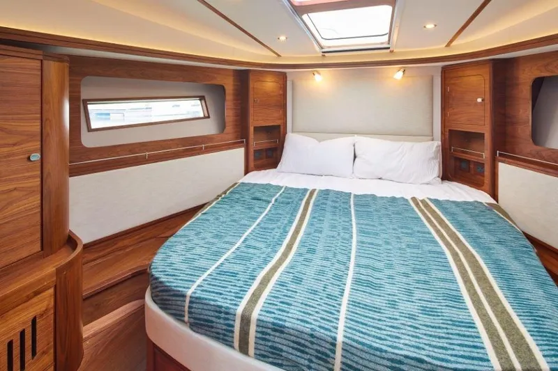 Slide: The Image of Luxurious 2025 Rustler 41 yacht cabin with cozy bed and elegant wood finish. - 25
