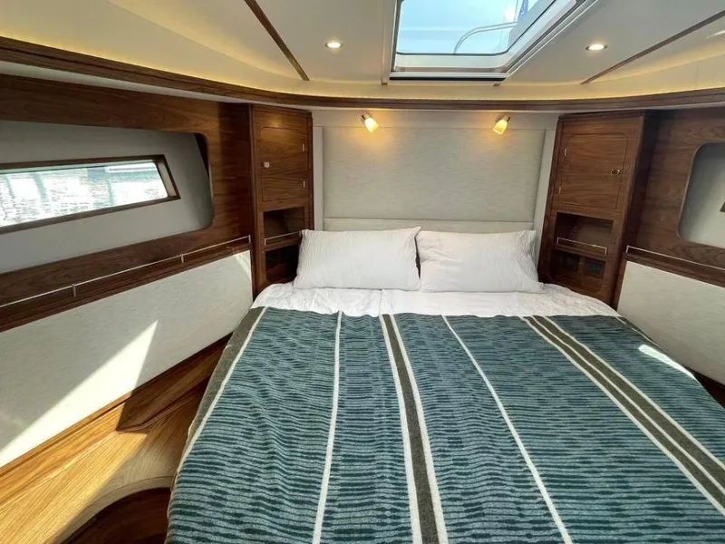 Slide: The Image of Luxurious cabin interior of 2025 Rustler 41 yacht with skylight and striped bedding. - 26