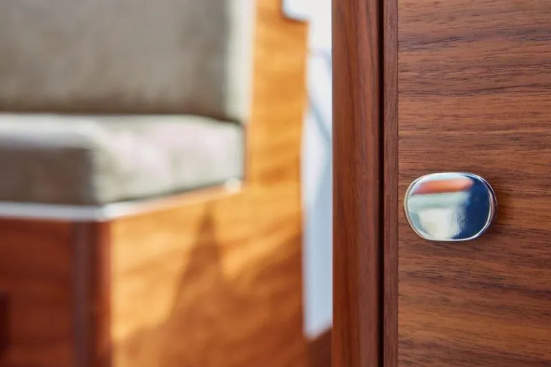 Slide: The Image of Wooden interior detail of 2025 Rustler 41 yacht, featuring polished metal knob. - 32