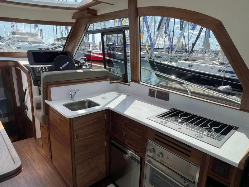 Slide: The Image of Modern kitchen interior of 2025 Rustler 41 yacht with stove, sink, and marina view. - 37