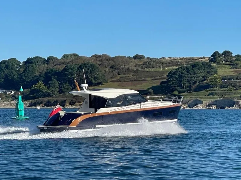 Slide: The Image of 2025 Rustler 41 yacht cruising on a sunny day, with scenic coastal background. - 4