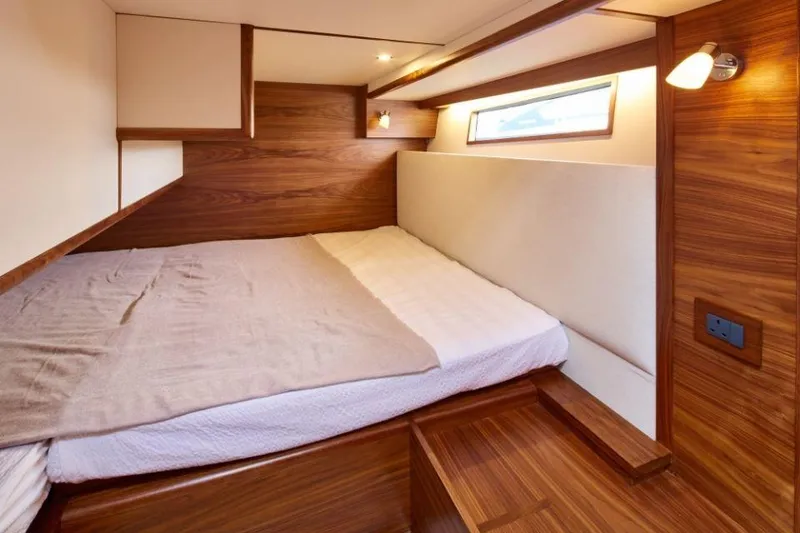 Slide: The Image of Luxurious cabin interior of 2025 Rustler 41 yacht with wooden finish and cozy bed. - 41