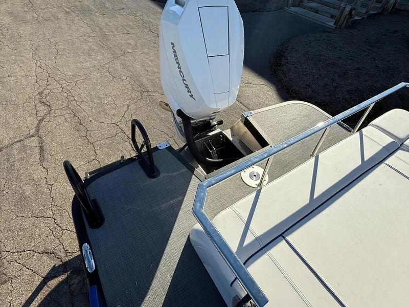 Slide: The Image of 2024 Bennington RX Sport Line boat with Mercury outboard motor, docked on a sunny day. - 10